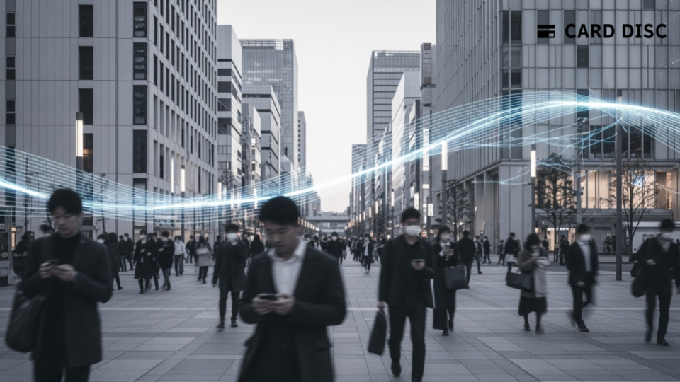 「Xard」最新版で法人カード決済の活用拡大を象徴する、現代日本の都市でスマホを使う人々のシルエットが描かれた画像です。